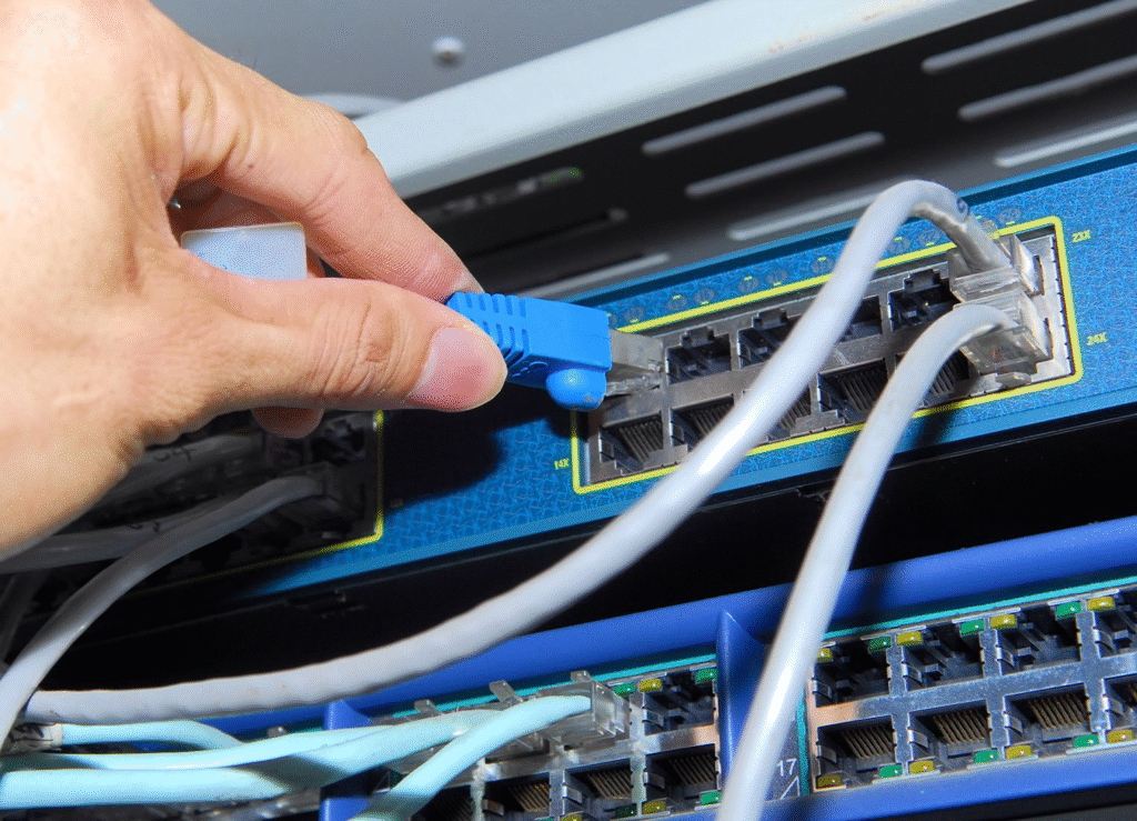 IT professional using a laptop to troubleshoot a malfunctioning network switch